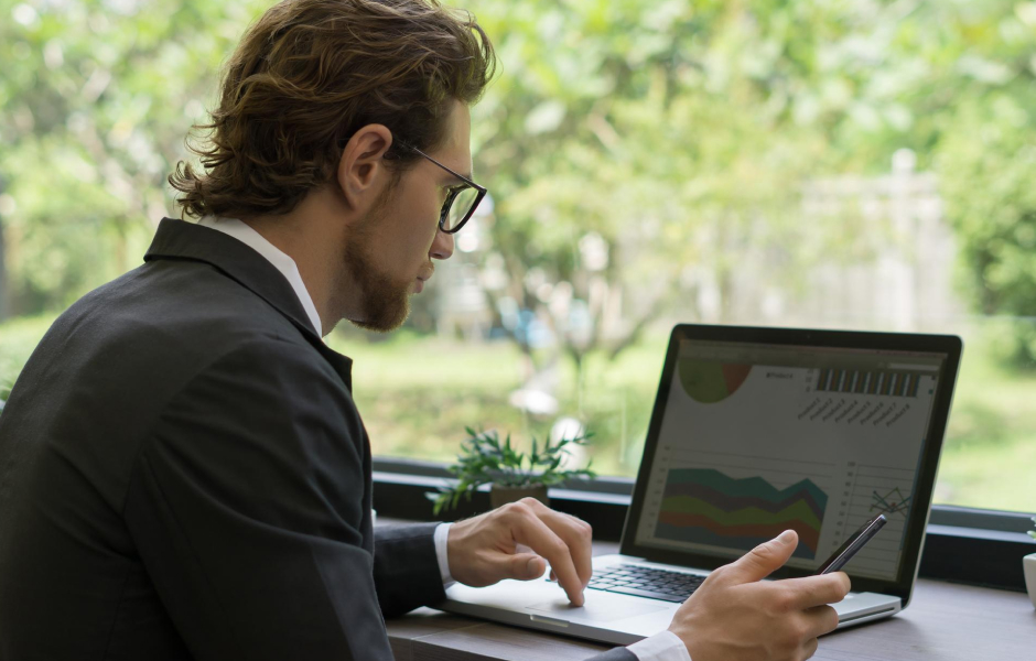 Businessman reviewing business goals on a laptop to determine outsourcing functions for proper alignment