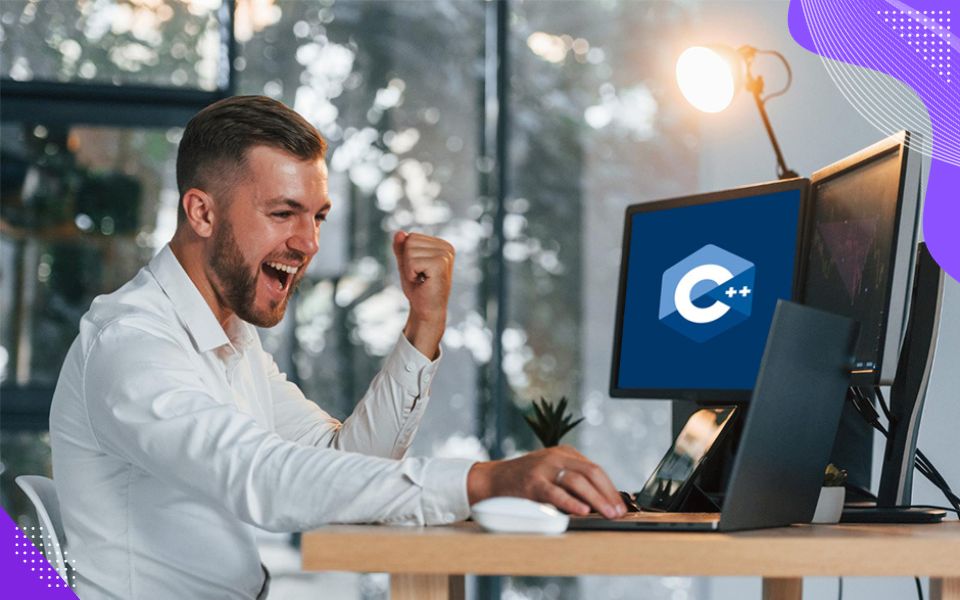 A happy client working in front of a computer highlighting the agility and innovation enabled by modern C++ systems.